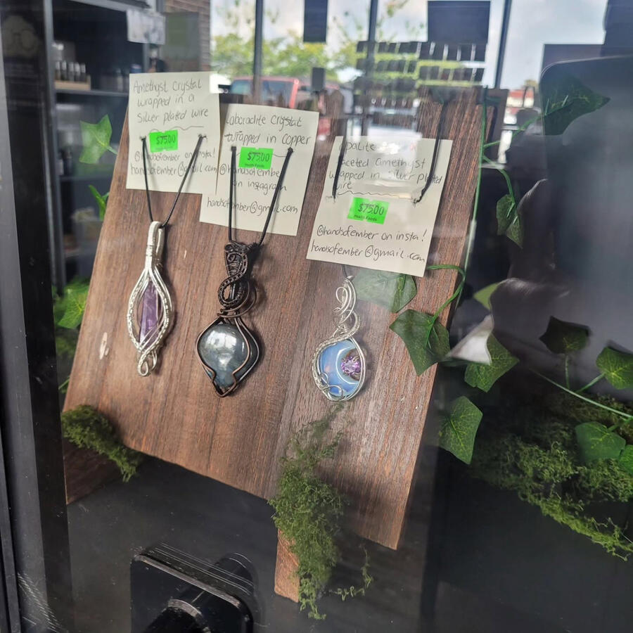 Showcase of 3 necklaces behind glass window